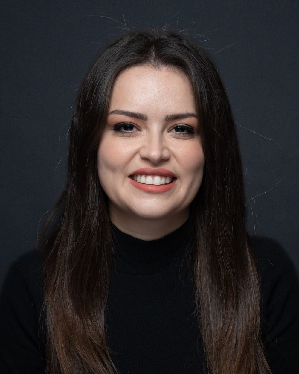 Nuria Casas, con el pelo largo y oscuro y un jersey de cuello alto, sonríe a cámara