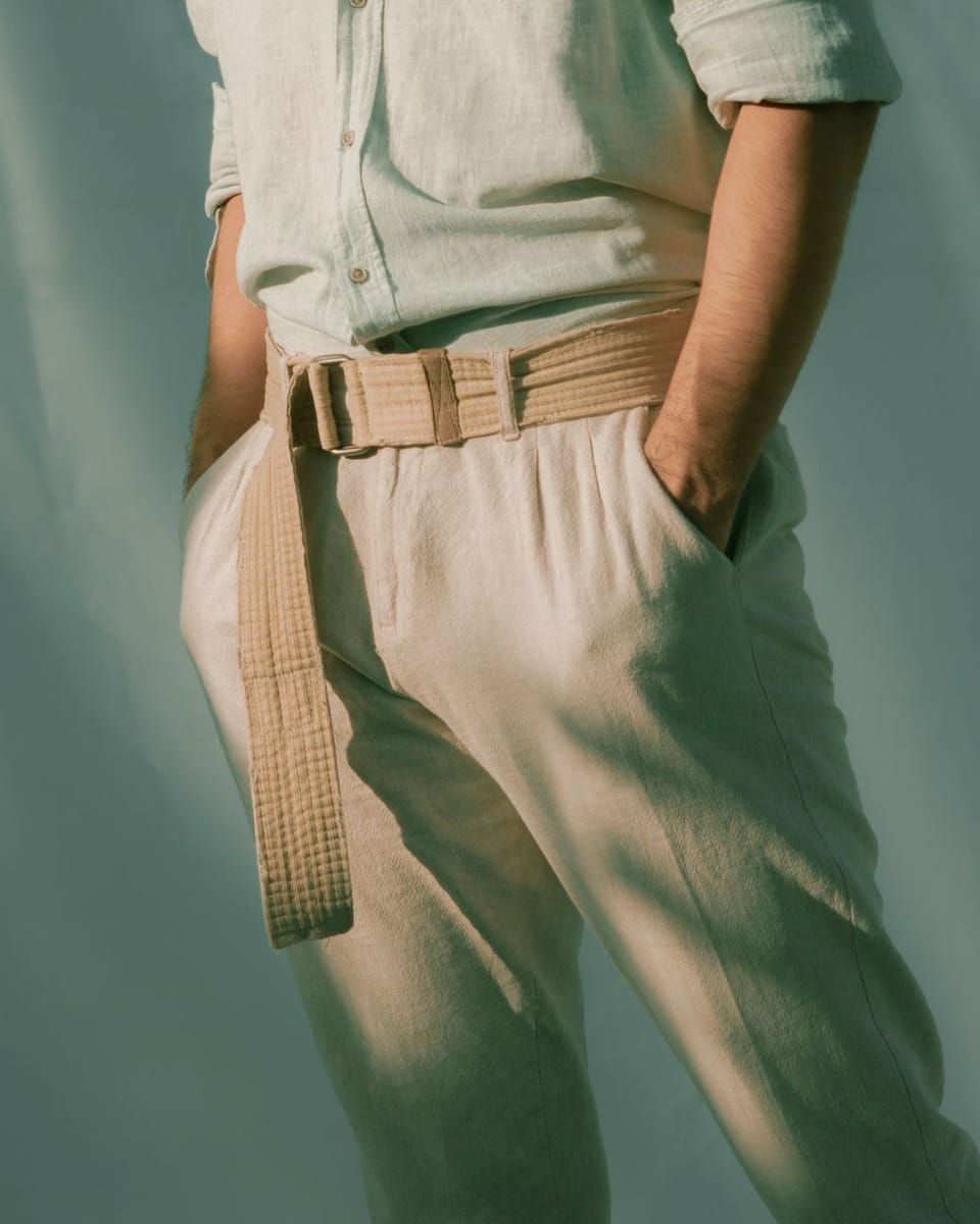 El pantalón Llevant de lino arena, con la mano en el bolsillo